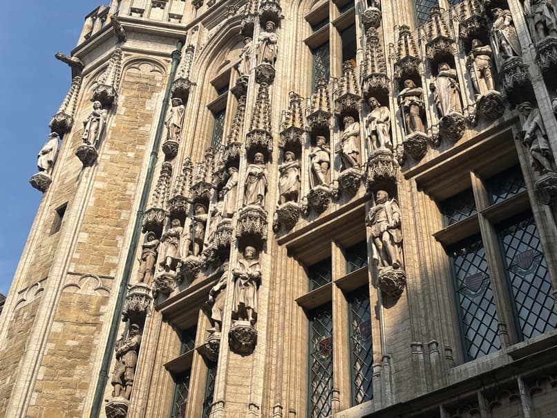 A close-up, low-angle shot of a building’s ornate facade, featuring multiple rows of gothic arches and sculptures.