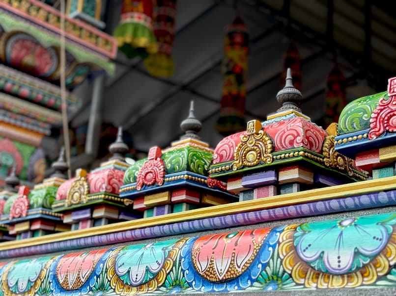 Colorful tops on the fence to a hindu temple.